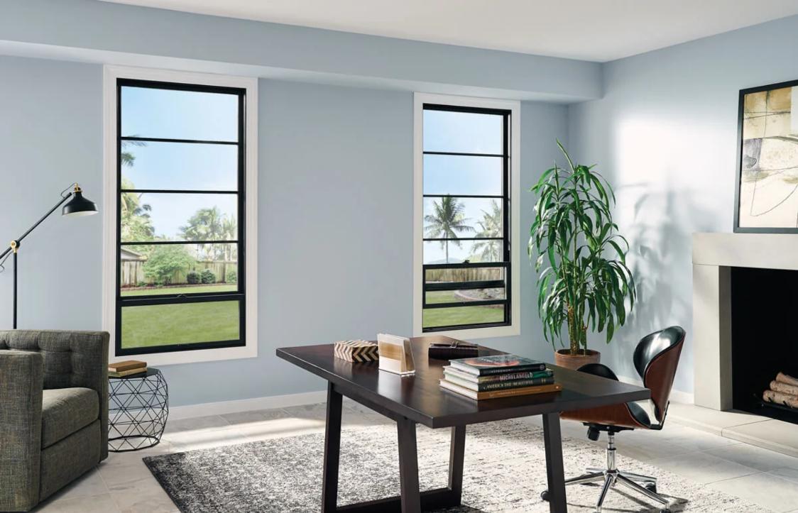 Modern home office with large black-framed windows overlooking a green yard, highlighting stylish and energy-efficient replacement windows and doors Ontario, CA.