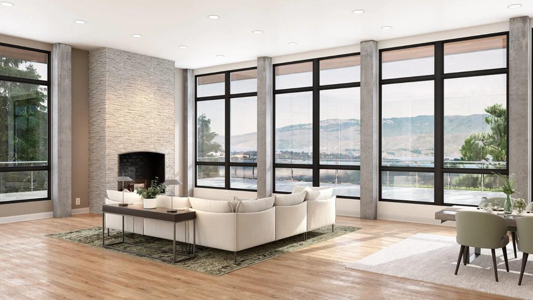 Spacious modern living room with floor-to-ceiling black-framed windows and scenic mountain views, showcasing energy-efficient replacement windows and doors Ontario, CA for enhanced natural light and style.