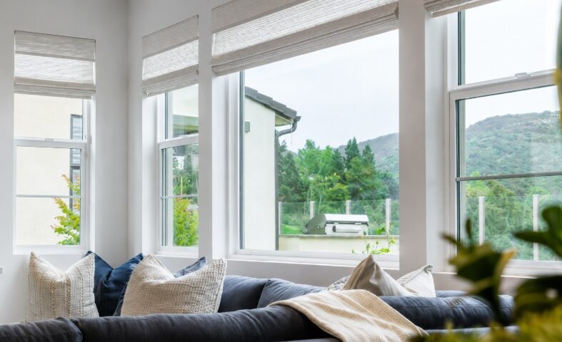 Modern living room with large replacement windows and Roman shades in Corona, CA