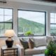 Modern living room with large black-framed windows overlooking hillside landscape in Corona, CA