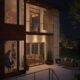 Modern two-story home with large illuminated windows overlooking an outdoor pool in Ontario, CA