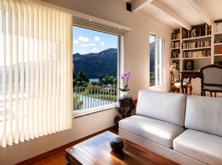 Vertical blinds framing Ontario, CA window replacement with scenic outdoor view