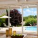 Large glass doors showcasing an Ontario, CA window replacement with a bright backyard view